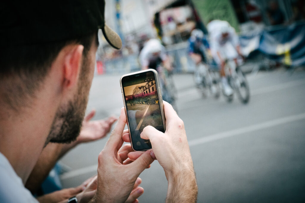 Zuschauer filmt das Radrennen mit dem Smartphone