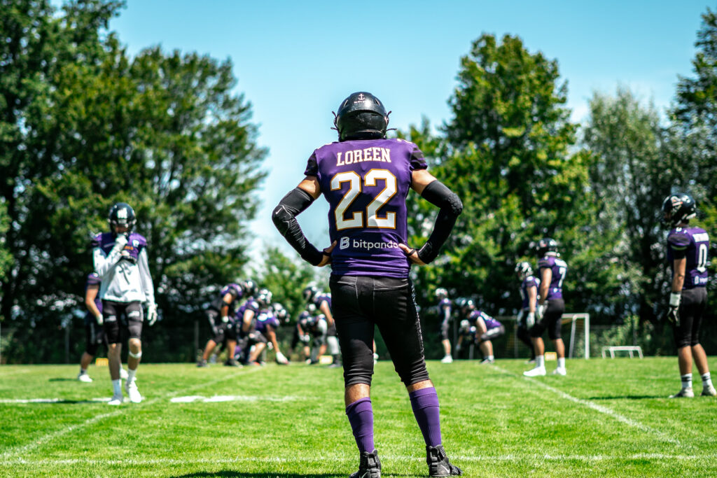 Football-Spieler in violettem Trikot auf dem Rasen