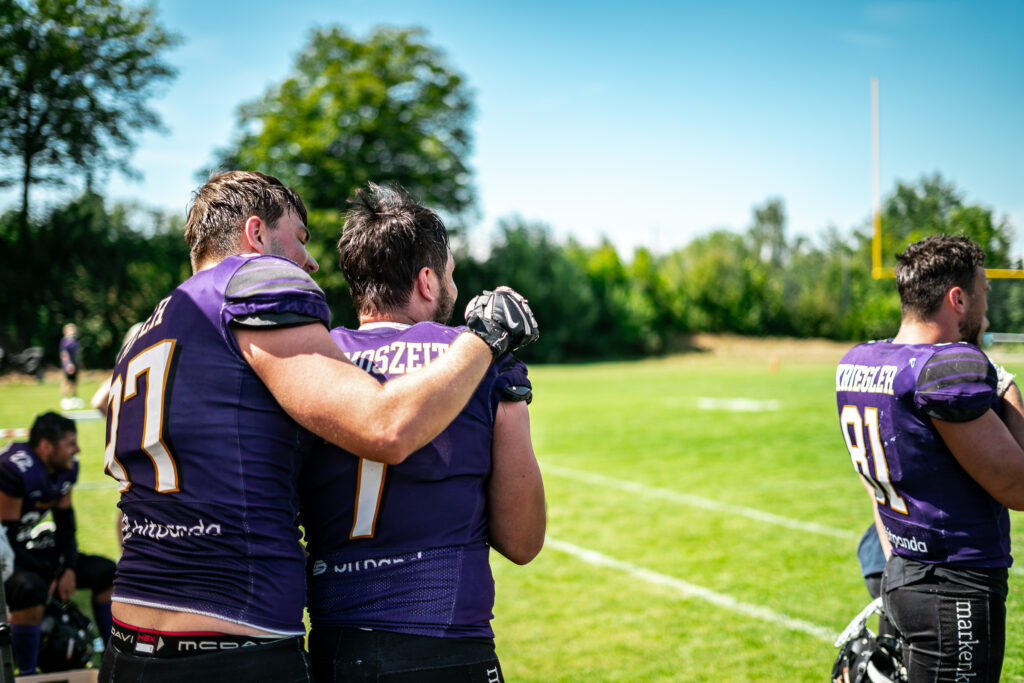 Football-Spieler umarmen sich auf dem Spielfeld