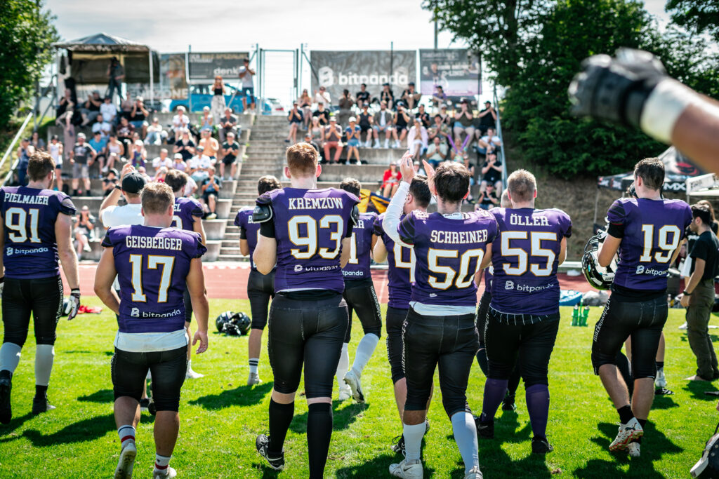 Spielergruppe in violetten Trikots am Spielfeldrand