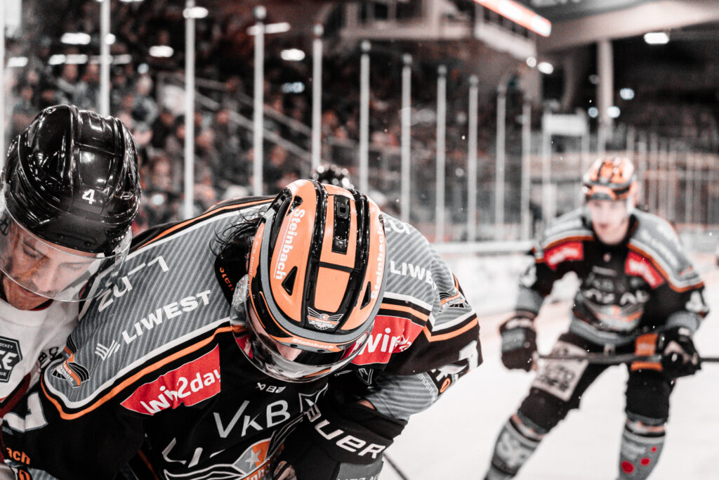 Zweikampf zwischen Eishockeyspielern an der Bande