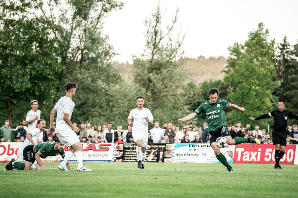 Spielszene bei einem Fußballspiel auf grünem Rasen