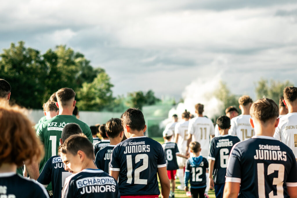 Spieler stehen vor dem Anpfiff in einer Reihe auf dem Platz