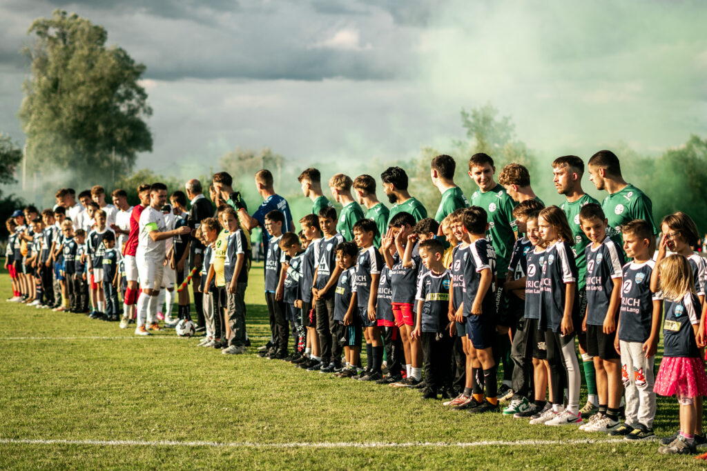 Mannschaft in einer langen Reihe auf dem Rasen vor dem Spiel