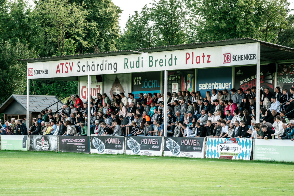Zuschauertribüne hinter dem Spielfeld bei einem Fußballspiel