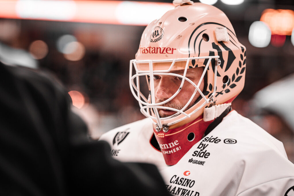 Eishockey-Torwart mit weißer Maske am Spielfeldrand